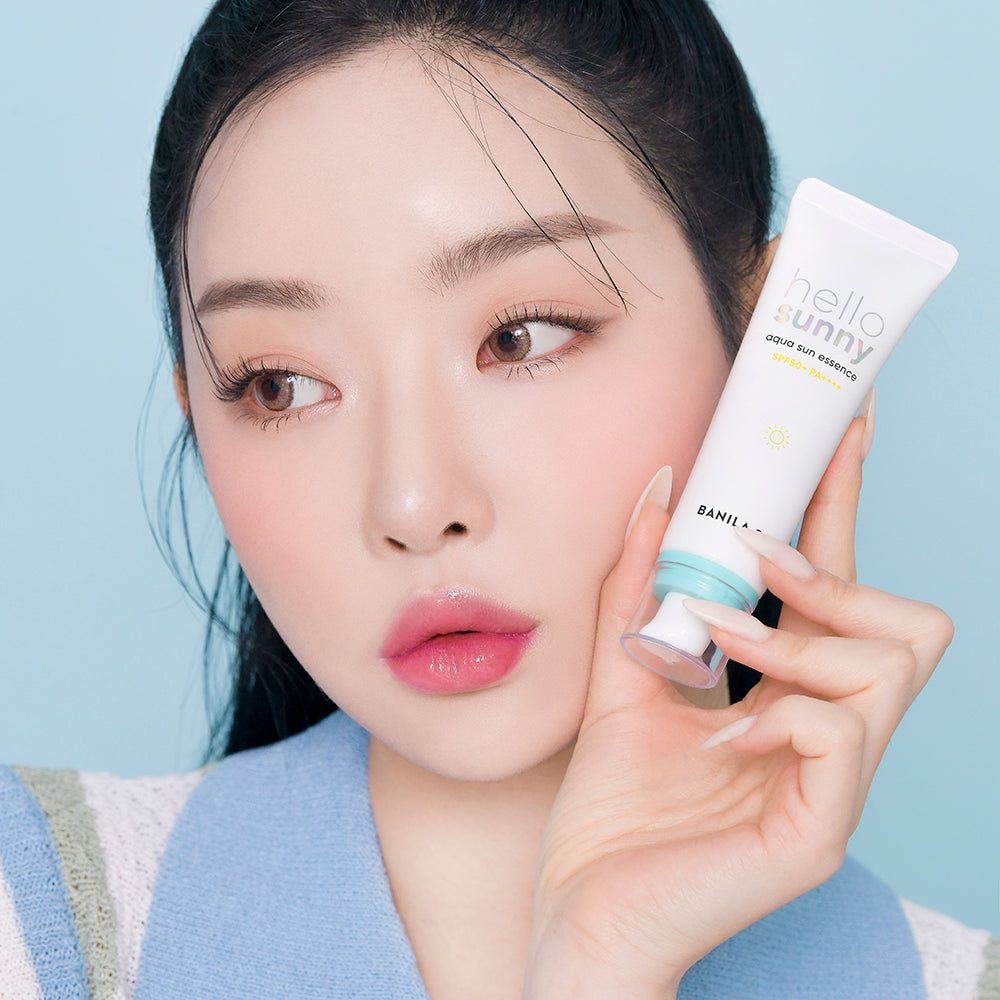 Frau hält BANILA CO Hello Sunny Aqua Sun Essence SPF50+ PA++++.