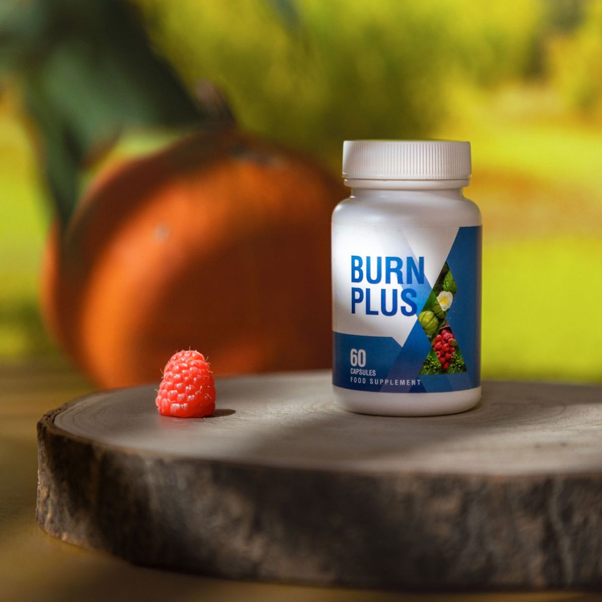 Weiße Flasche mit blauem Etikett. Aufschrift: BURN PLUS, 60. Eine Himbeere liegt auf einem Holzstück. Hintergrund unscharf.