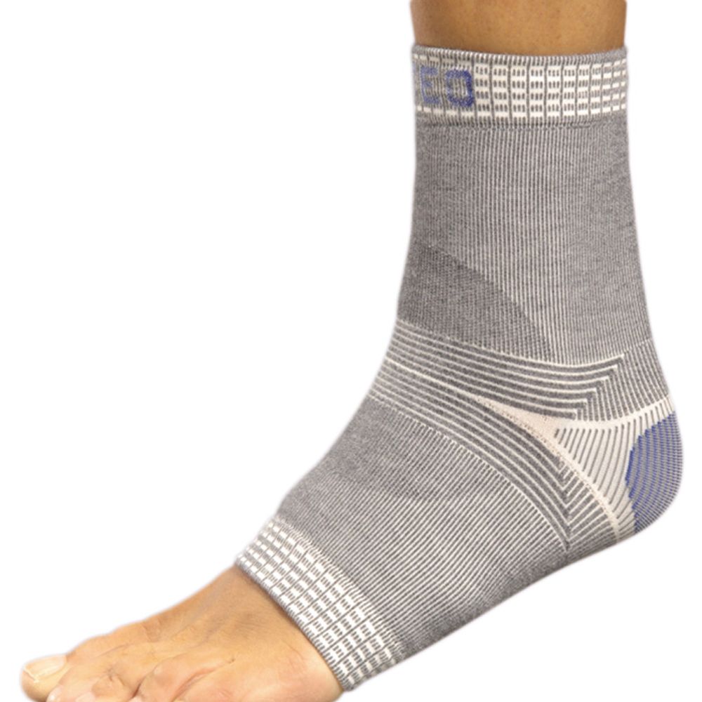 Graue Sprunggelenksbandage am Fuß. Bandage mit weißem und blauem Akzent. Rippenstruktur. Quadratisches Muster am oberen und unteren Rand.