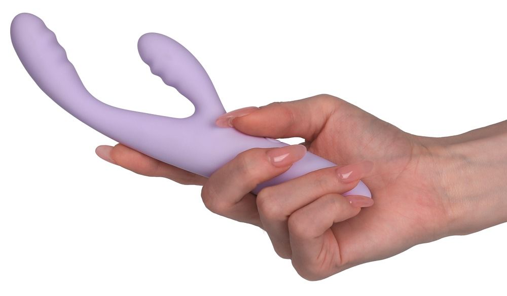 Lila Vibrator in Hand gehalten. Ergonomische Form mit zwei abgerundeten Enden. Glatte Oberfläche.