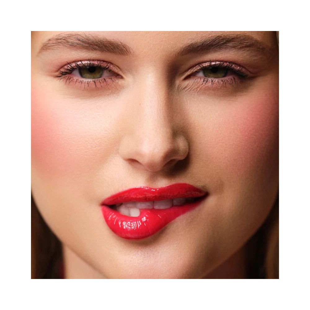 Nahaufnahme eines Mundes mit vollen, roten Lippen, die leicht aufgebissen sind. Glänzendes rotes Lippenfluid.