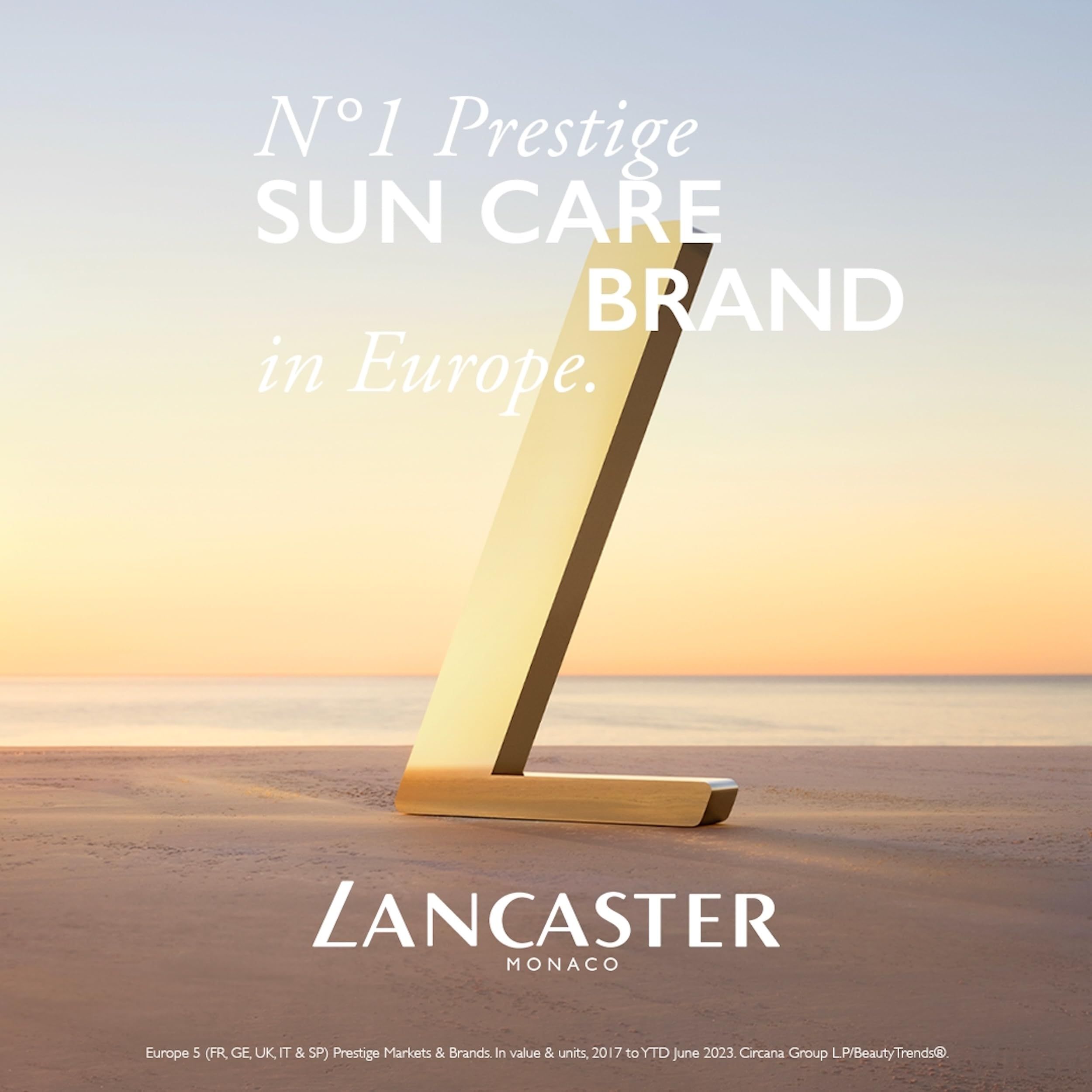 Goldenes L-Logo auf Strandhintergrund. Text: N°1 Prestige SUN CARE BRAND in Europe. Lancaster Monaco.