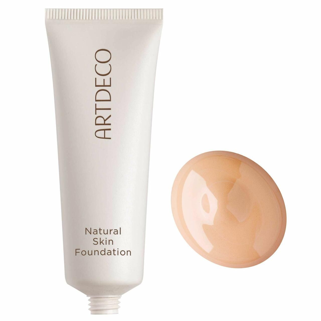 Beige Foundation-Tropfen neben Tube. Tube mit "ARTDECO" und "Natural Skin Foundation" Schriftzug. Weißes Tube, beige Tropfen.