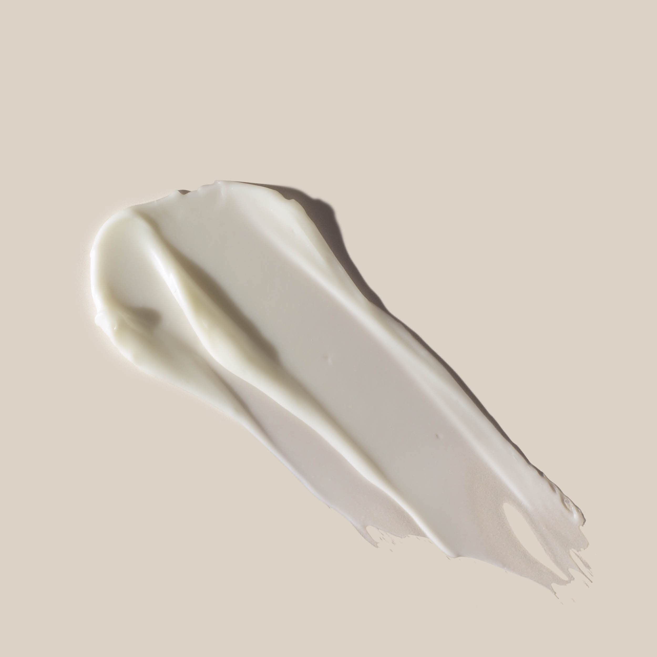 Creme-Abstrich auf hellem Hintergrund. Weiße Creme mit glatter Textur. Form: geschwungen.