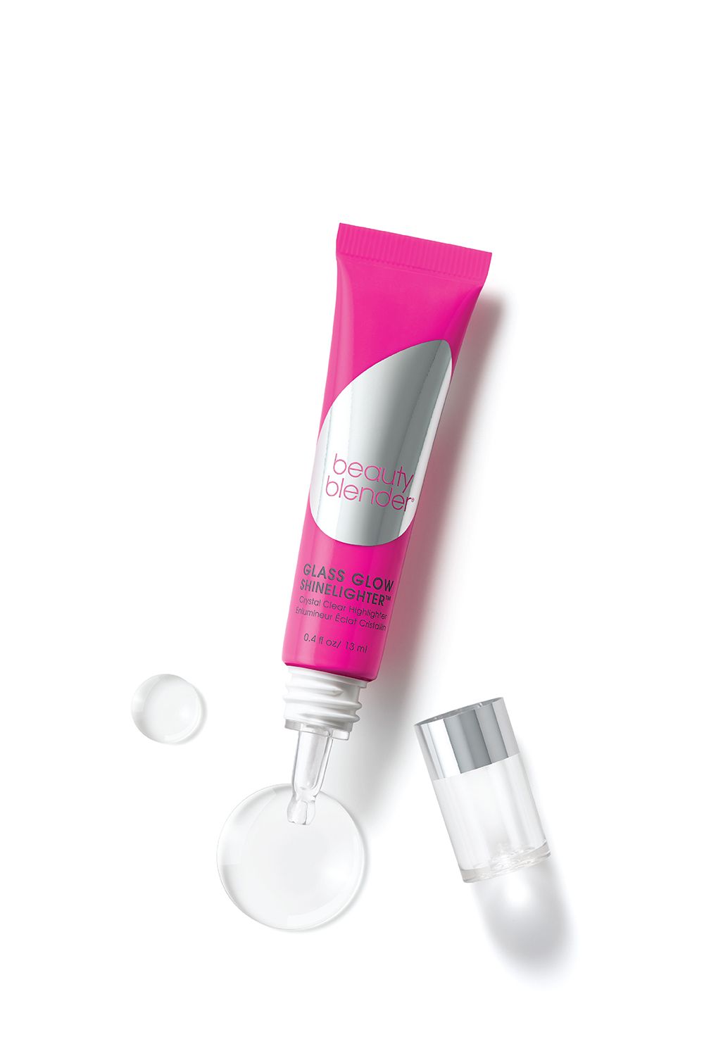 Rosa Tube mit "beautyblender"-Logo. "GLASS GLOW SHINELIGHTER"-Produkt. Tropfen und Kappe daneben.