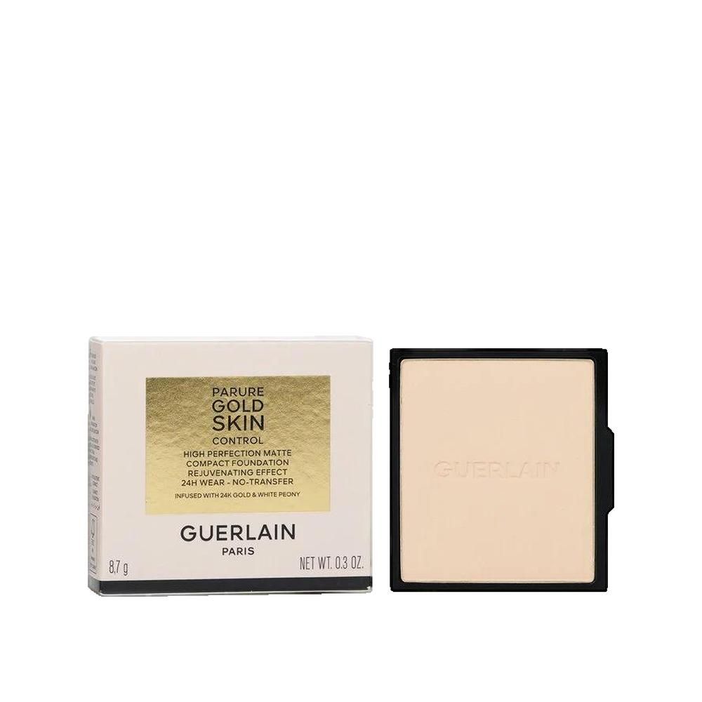 Kompakt-Foundation und Verpackung. Weiße Schachtel mit goldenem Schriftzug. Schwarze Kompakt-Foundation. Aufschrift: Parure Gold Skin Control.