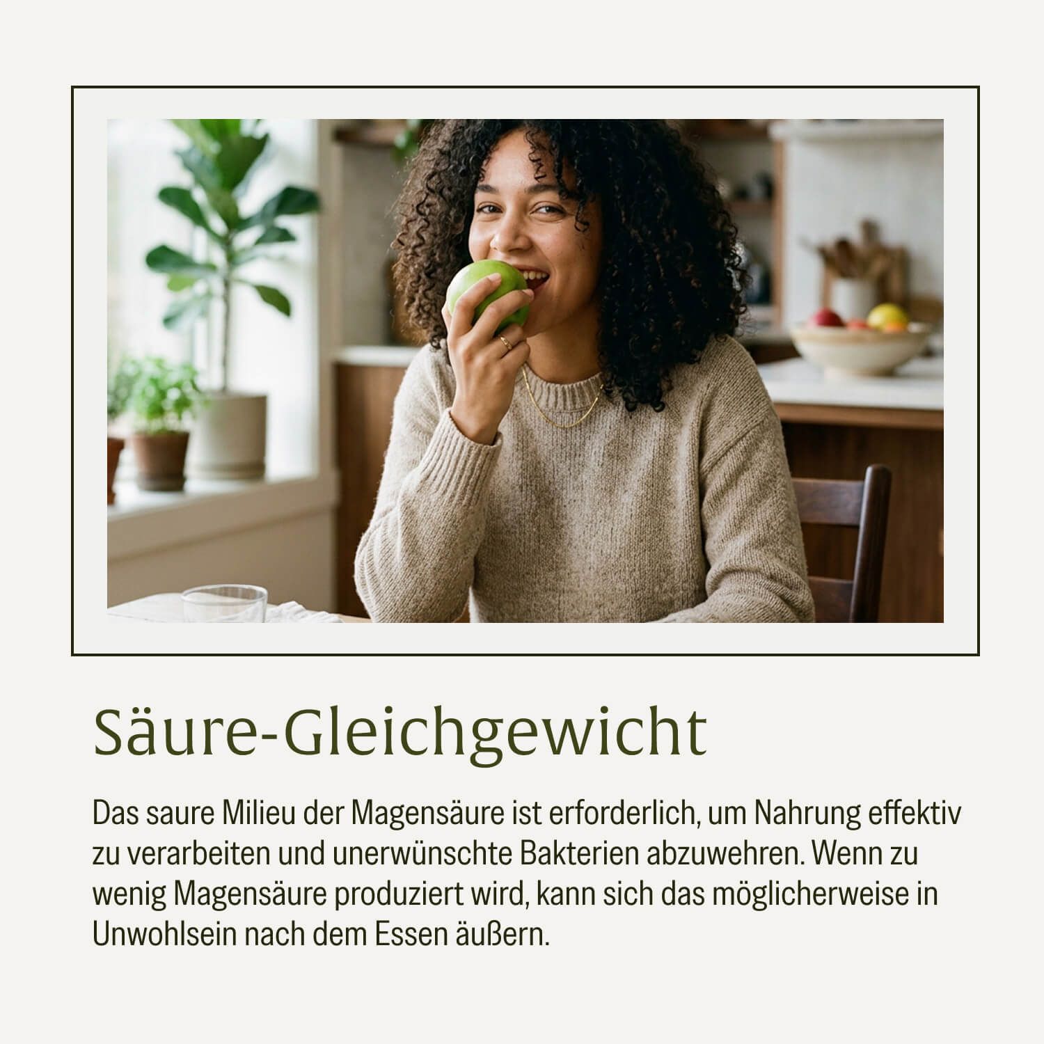 Frau isst einen grünen Apfel in einer Küche. Text: "Säure-Gleichgewicht".