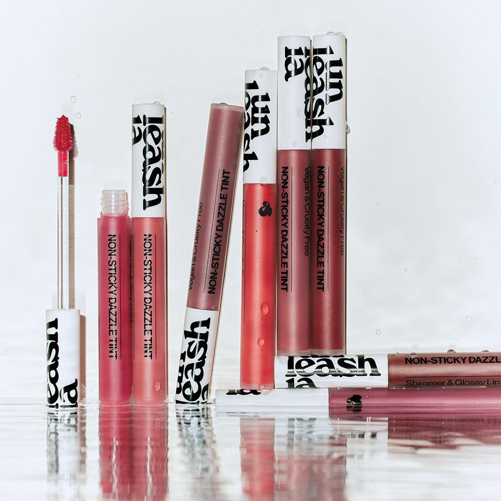Mehrere Lipgloss-Tuben mit weißer Kappe und schwarzem Schriftzug. Aufschrift: Non-Sticky Dazzle Tint.