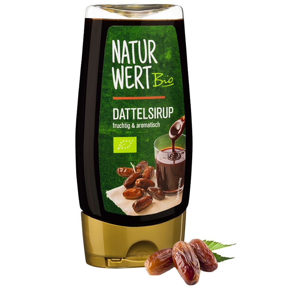 Flasche mit braunem Sirup. Aufschrift: NaturWert Bio Dattelsirup. Bio-Siegel. Datteln liegen daneben.