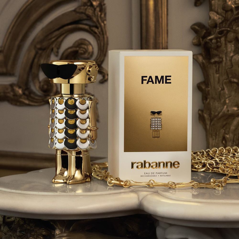 Paco Rabanne Fame Eau de Parfum. Goldene Flasche und Verpackung. Aufschrift: FAME, rabanne.
