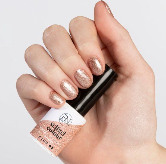 Hand mit lackierten Nägeln und Nagellackflasche. Flasche mit Aufschrift "selfgel colour" und "Pink Quartz".