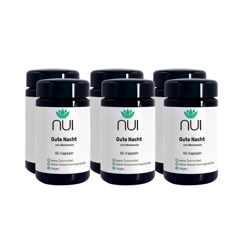Sechs Flaschen NUI Gute Nacht mit Melatonin. Schwarze Deckel, weiße Etiketten mit Logo und Produktinformationen. 60 Kapseln pro Flasche.