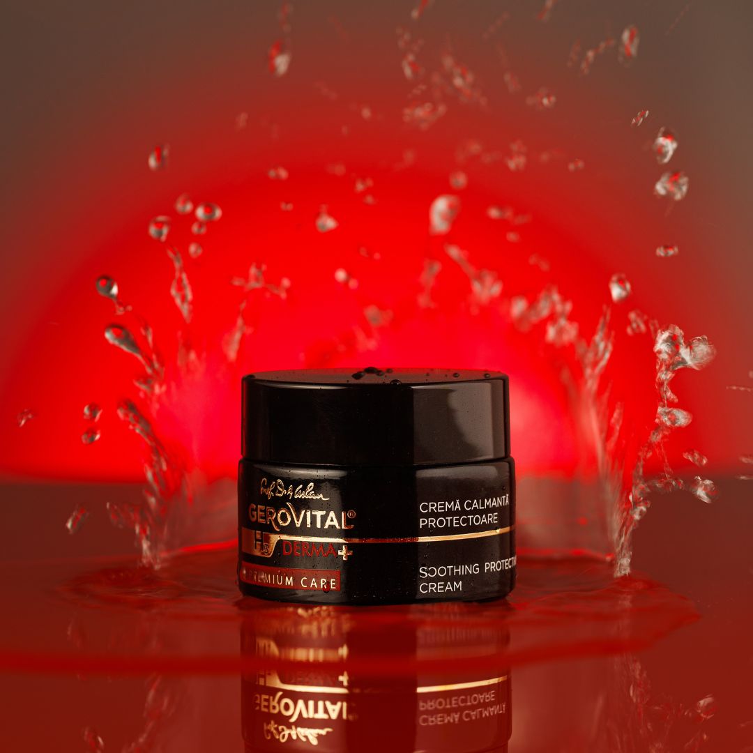 Schwarzer Tiegel mit goldener Schrift. Text: Gerovital Derma+, Créma calmanta protectoare, Soothing Protective Cream. Wasser spritzt.