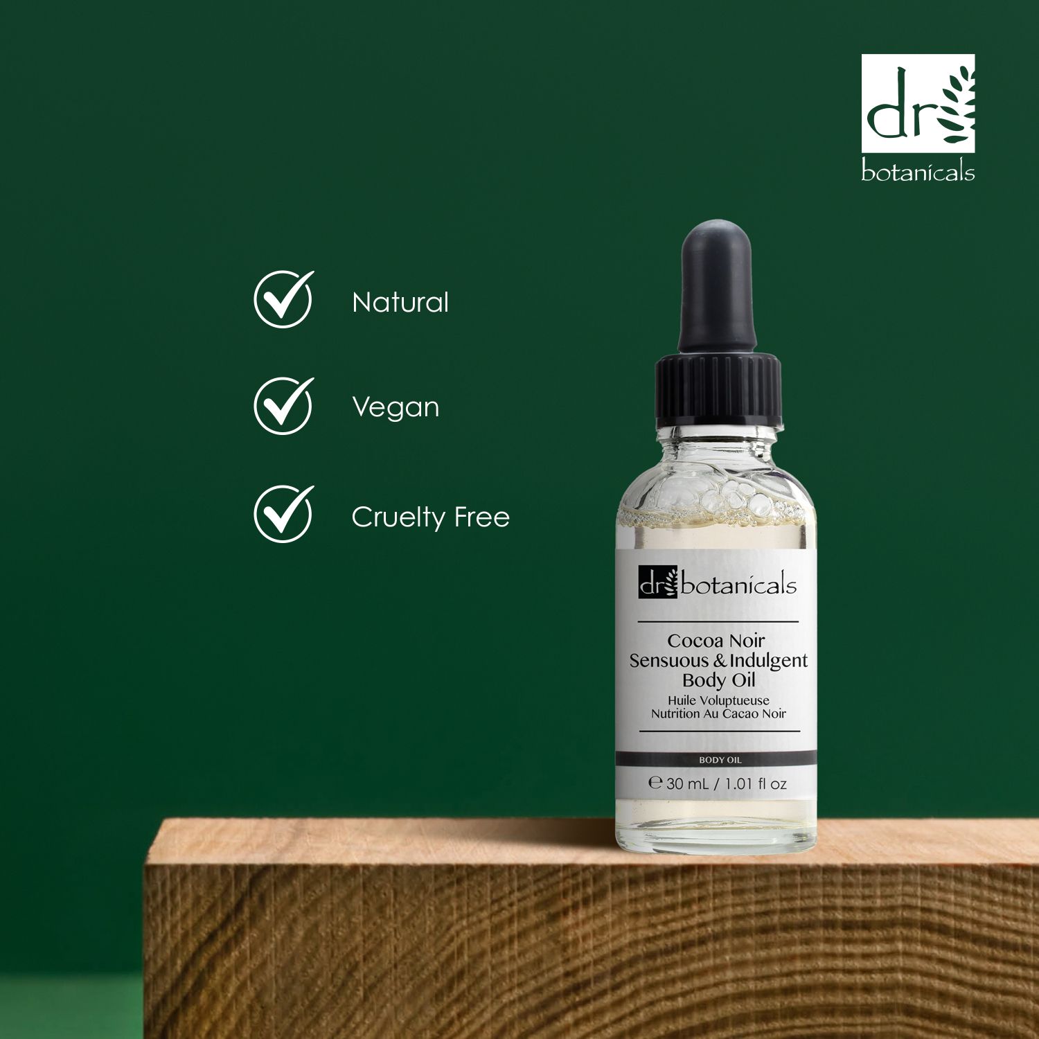 Körperöl-Flasche mit Pipette auf Holz. Symbole: Natural, Vegan, Cruelty Free. Marke: Dr Botanicals.