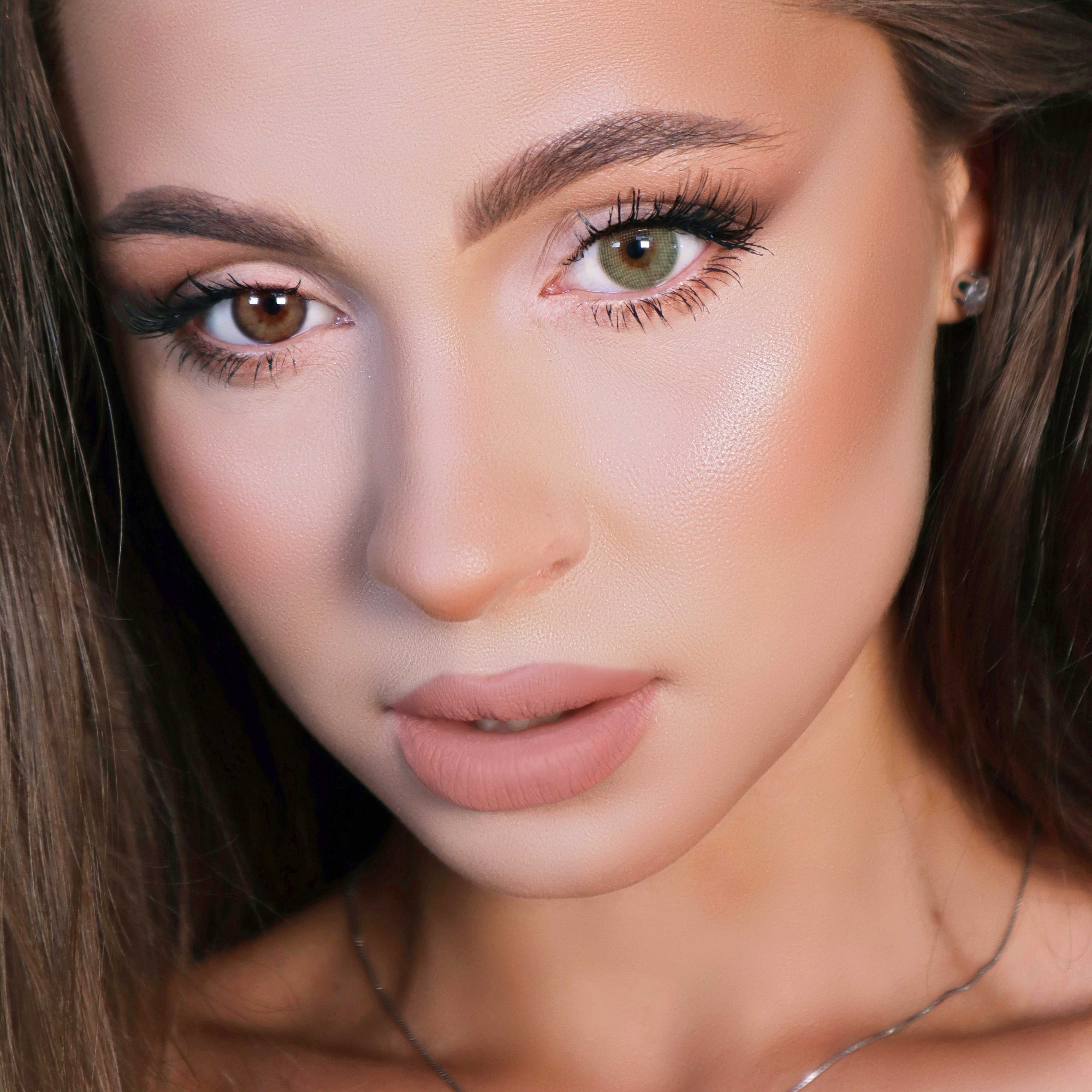 Porträt einer Frau mit zwei verschiedenfarbigen Augen. Ein Auge braun, das andere olivgrün. Natürliches Make-up.