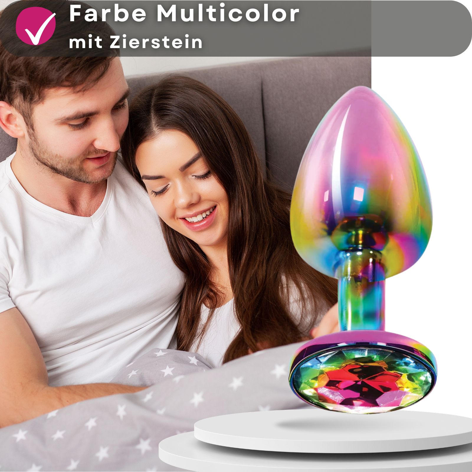 Analplug, multicolor, Metall, Zierstein. Paar küsst sich. Produkt auf Podest.