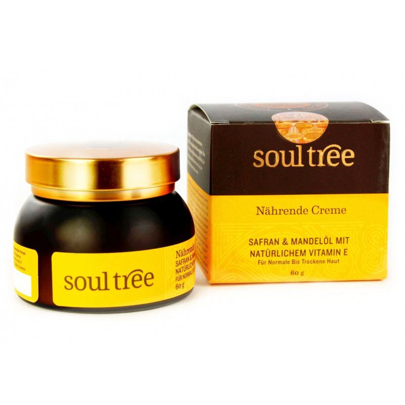 Dunkles Glas mit goldfarbenem Deckel und gelbem Etikett. Daneben eine braune Schachtel mit gelber Schrift. Aufschrift: soul tree, Nährende Creme.