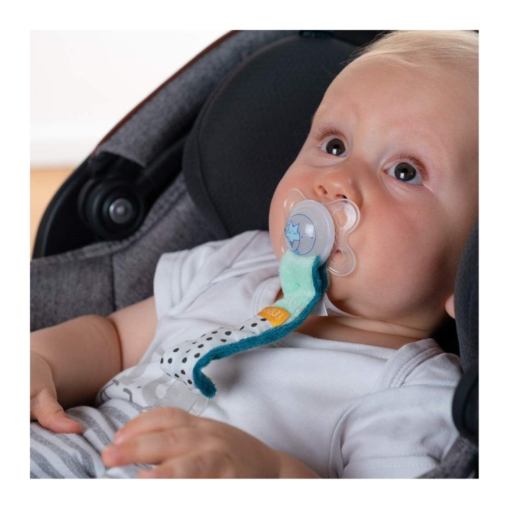 Baby mit Schnuller und Schnullerkette. Grün-weiß gepunktetes Band, gelber Akzent, transparenter Schnuller.