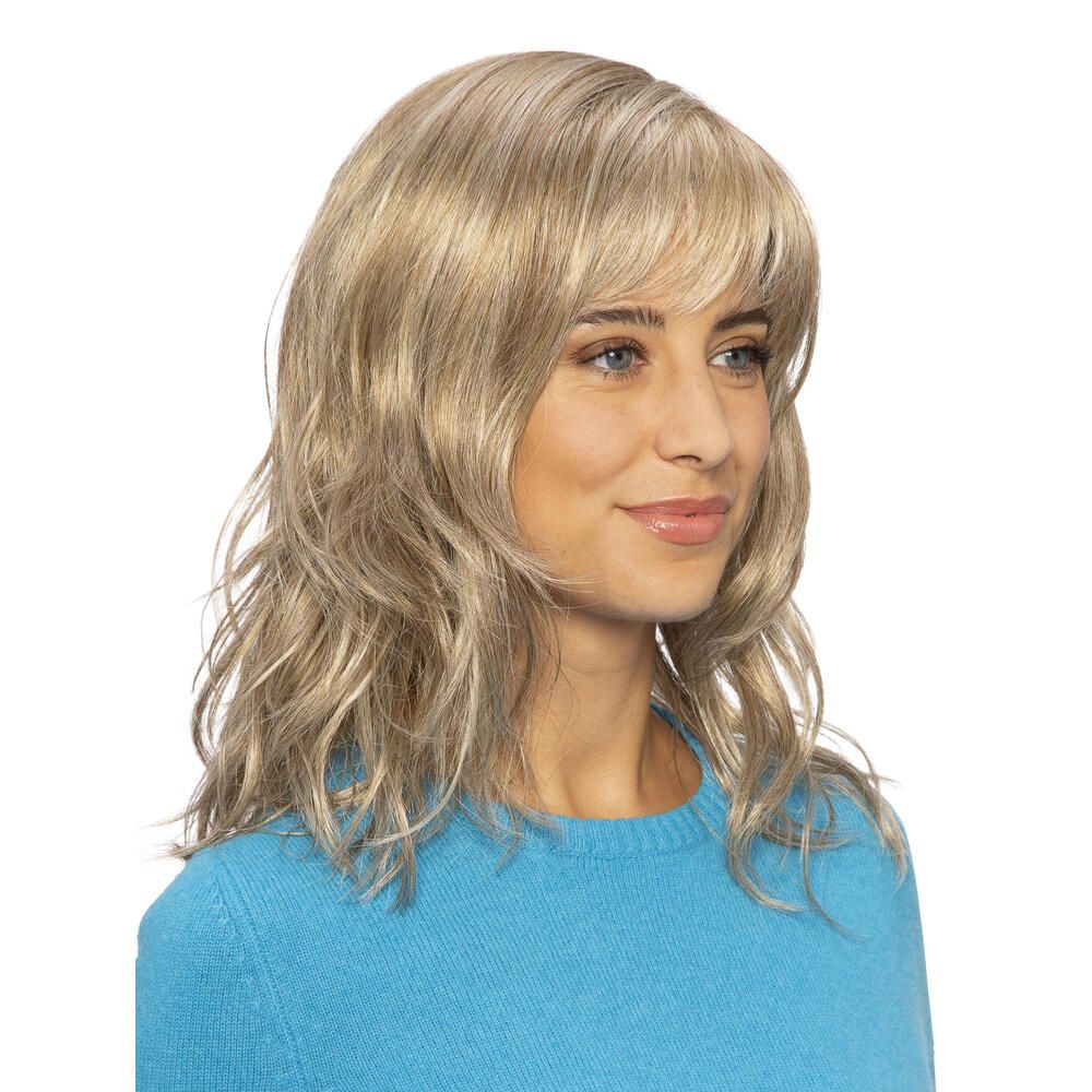 Blond gewellte Perücke mit Pony, getragen von einer Frau. Seitenansicht, Blickrichtung nach links.