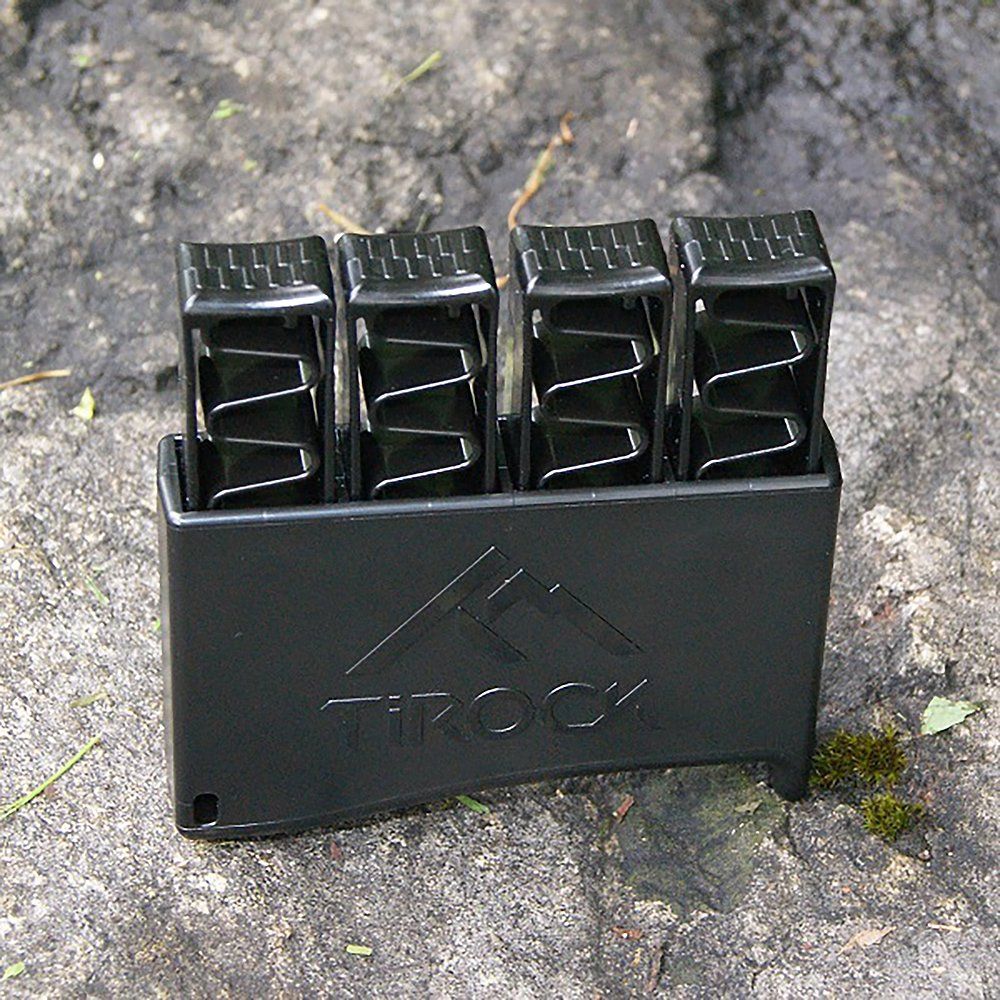 Schwarzes Fingertrainer-Set Ti-Hand auf Stein. Vier Federn stecken in einem Basis-Element mit TiRock-Logo.