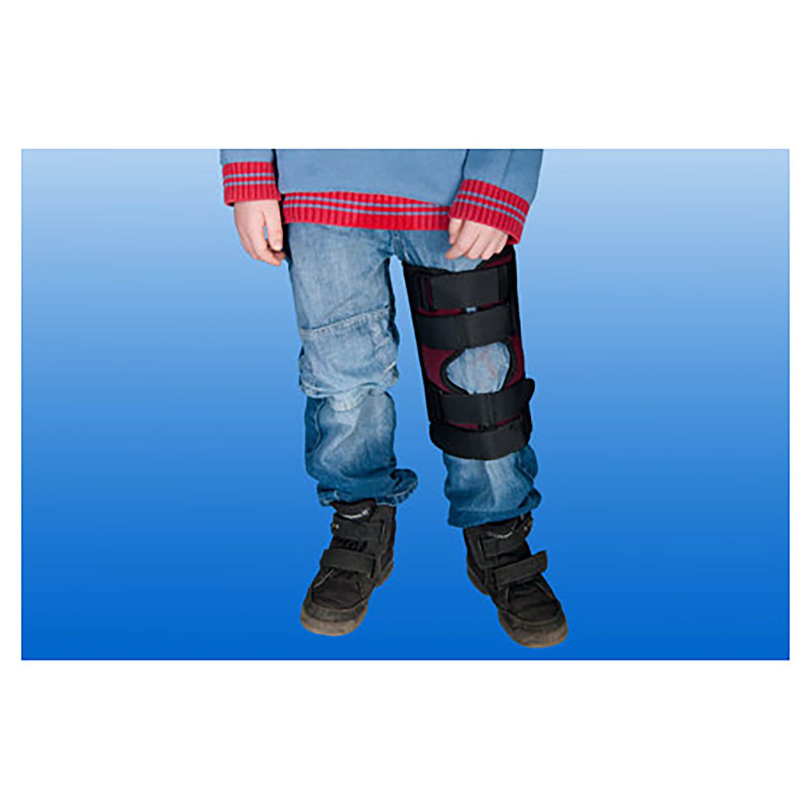 Knieschiene am Bein eines Kindes. Schwarze Gurte, rotes Innenfutter. Klettverschlüsse. Größe M.