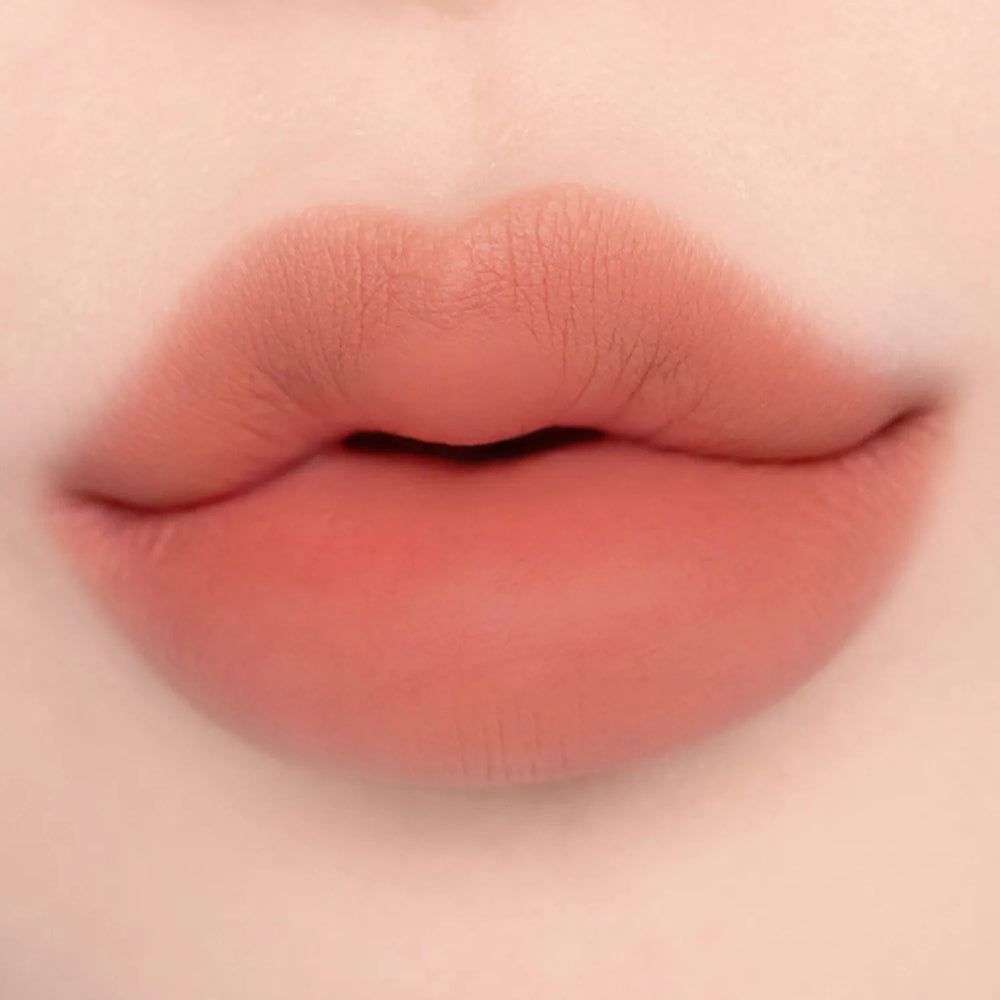 Lippen in Koralle mit mattem Finish.