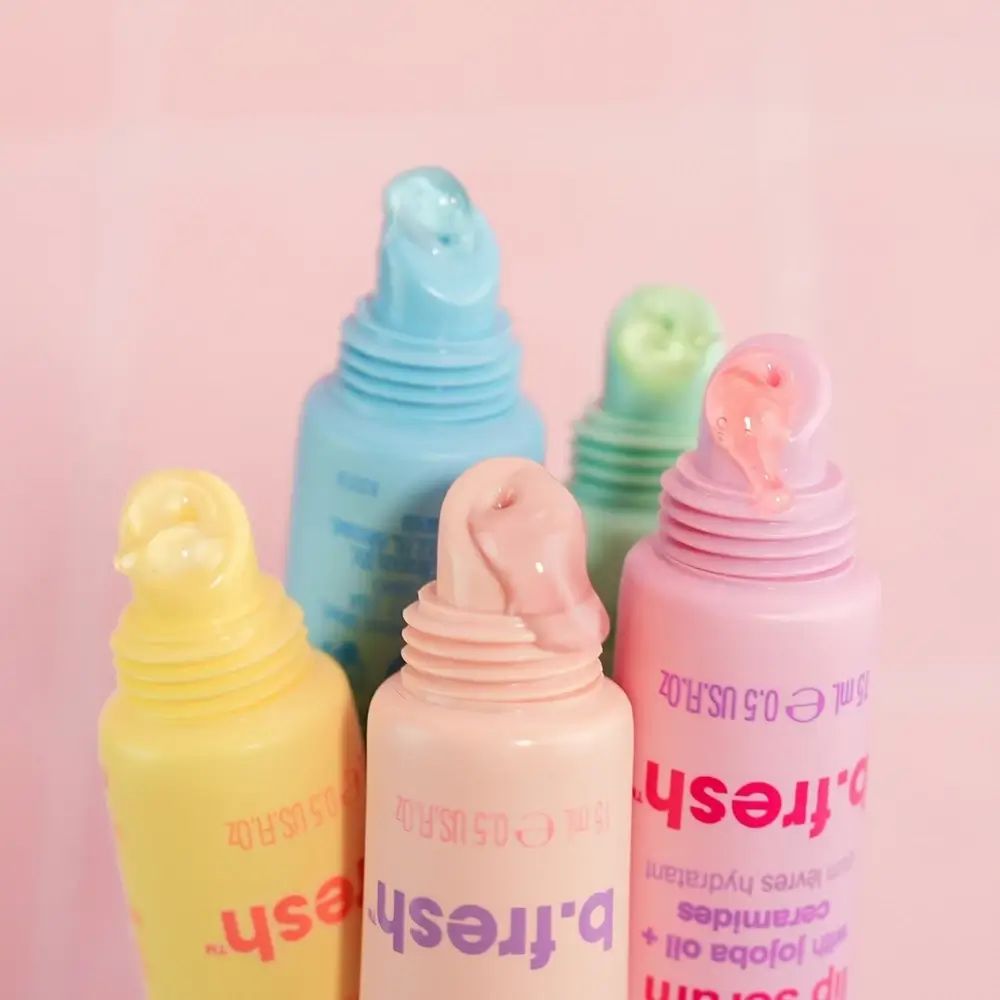Nahaufnahme von fünf Lippen-Serum-Tuben. Verschiedene Farben, Produkt ist aus der Tube gedrückt. Marke: b.fresh.