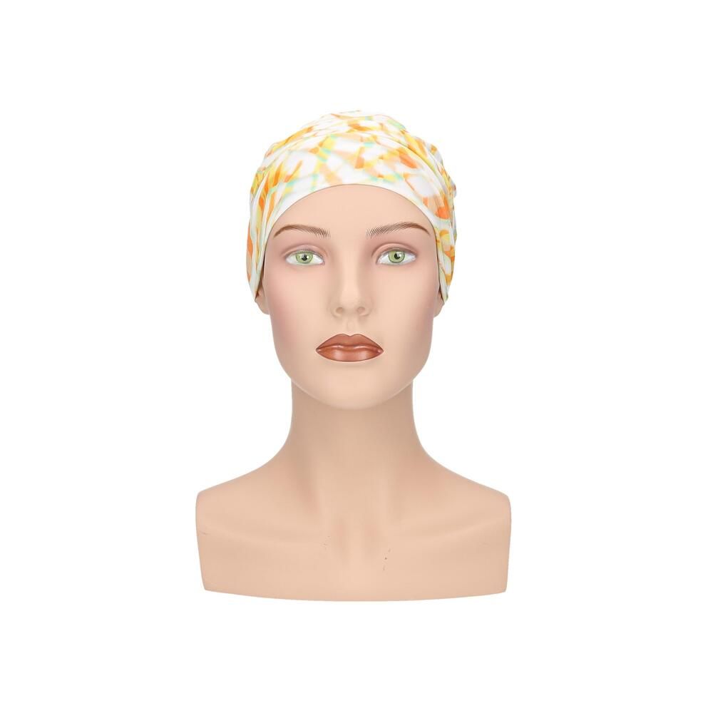 Turban mit gelb-orangem Muster auf einem Schaufensterpuppenkopf. Vorderansicht.