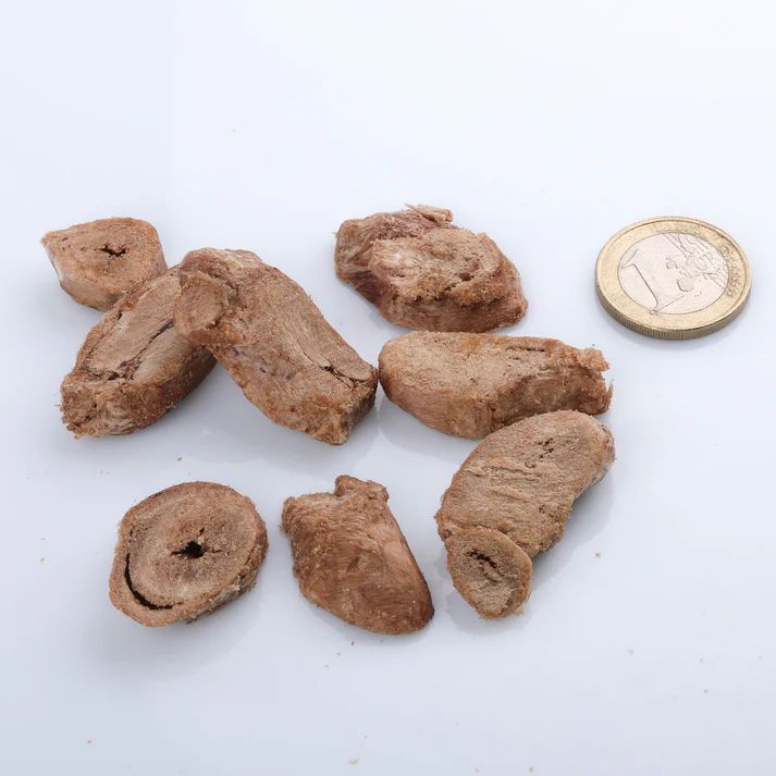 Getrocknete Hühnerherzen, Ansicht von oben. Einige Herzen sind halbiert. Eine Münze liegt daneben.