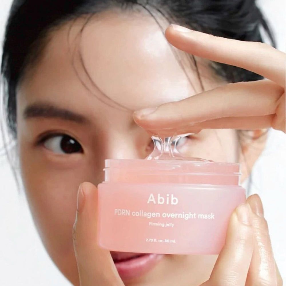 Rosa Dose mit transparentem Gel. Aufschrift: Abib PDRN collagen overnight mask. Eine Hand hält das Gel.