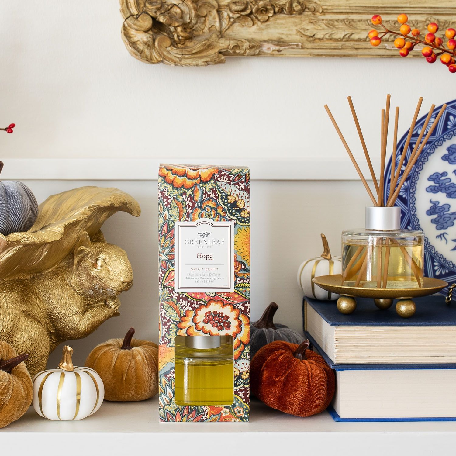Greenleaf Hope Reed Diffuser mit 8 Stäbchen neben einer bunten Verpackung, umgeben von Herbstdekorationen wie Kürbissen.