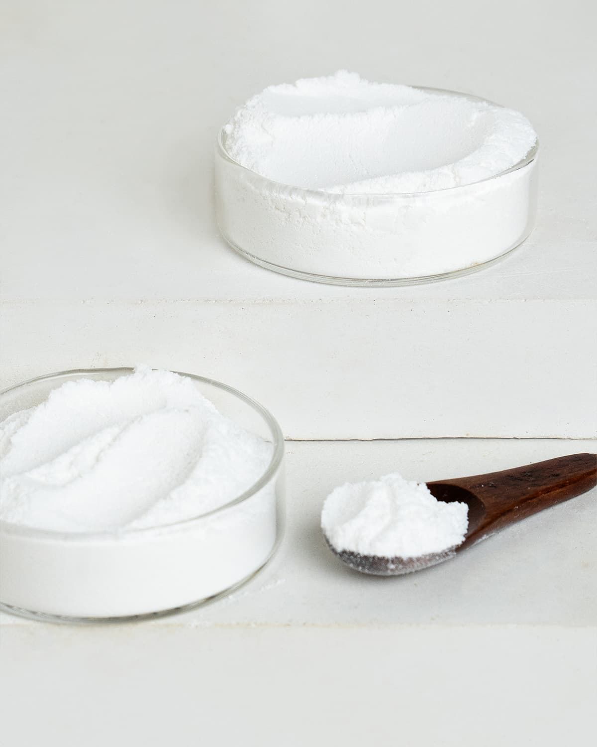 Verpackung mit L-Phenylalanin Pulver von buxtrade, daneben ein Würfel mit Pulver.