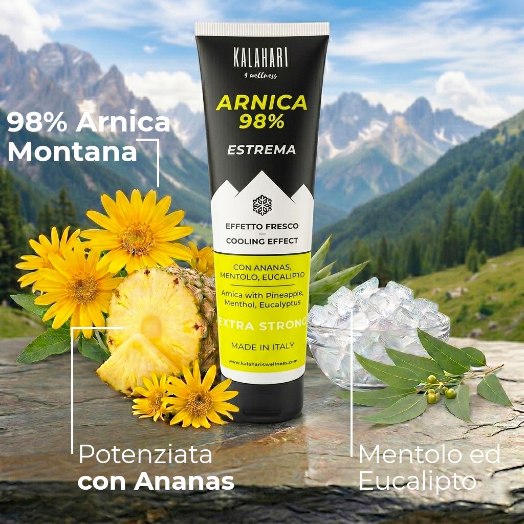 Tube "Arnica 98% Estrema" vor Bergkulisse mit Arnika, Ananas, Minze und Eukalyptus.