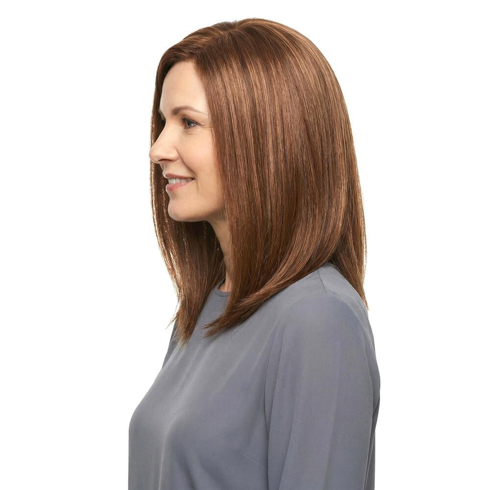 Frau mit brauner Perücke, schulterlang, seitlich. Glattes Haar mit helleren Strähnen. Trägt graues Oberteil.