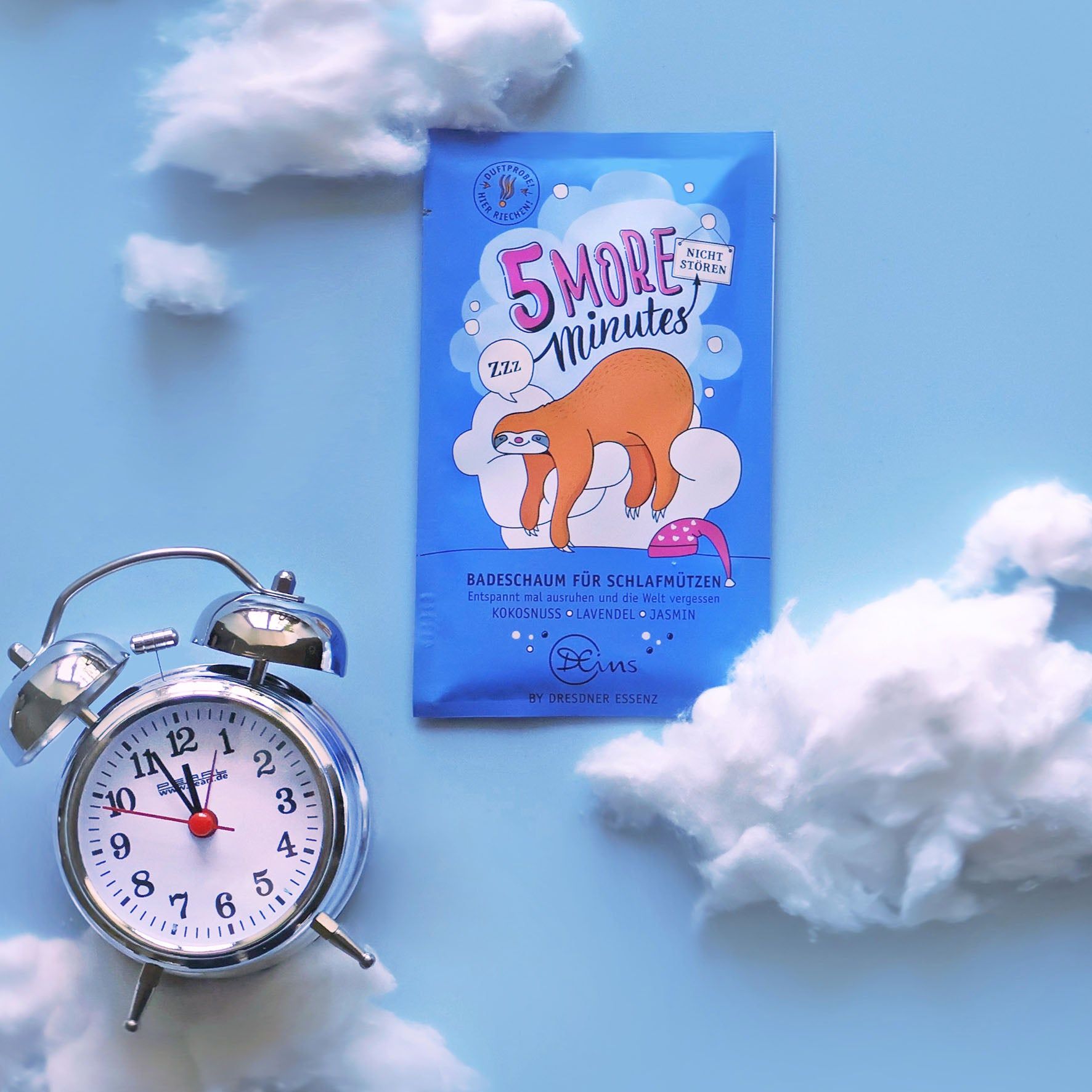 Emballage avec paresseux sur nuage, à côté d'un réveil et de nuages. Texte: 5 MORE MINUTES, mousse de bain.