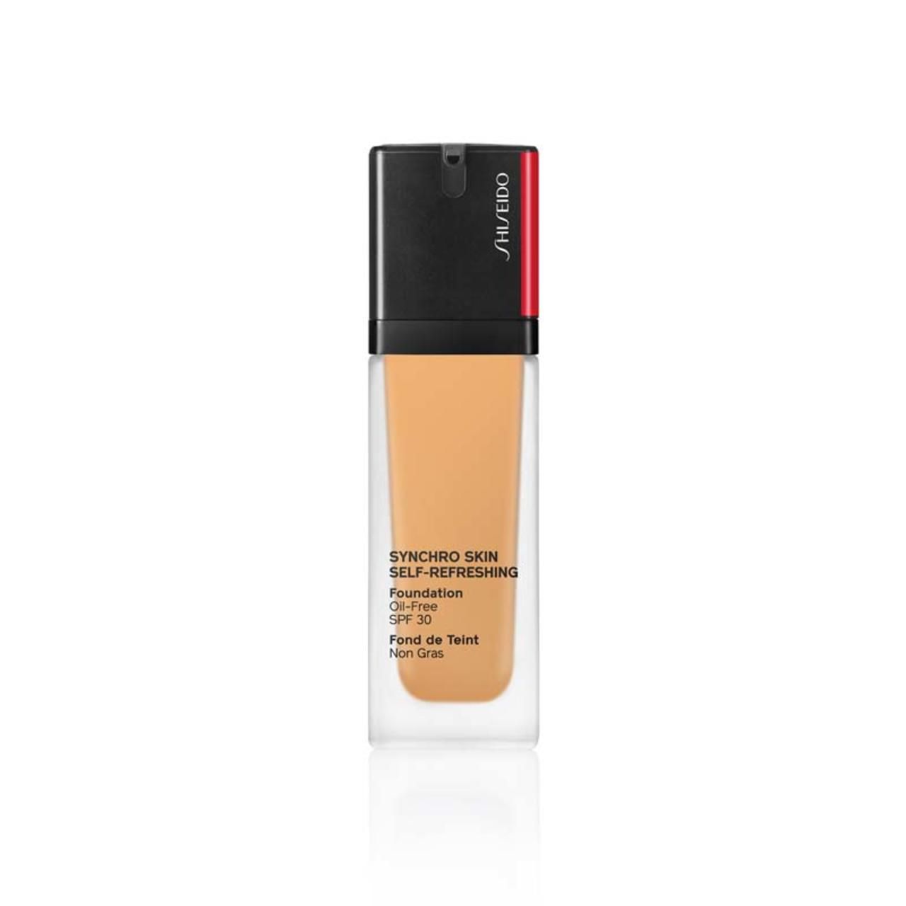 Shiseido Synchro Skin Foundation. Transparente Glasflasche mit schwarzem Deckel. Produktname und Details auf dem Etikett.