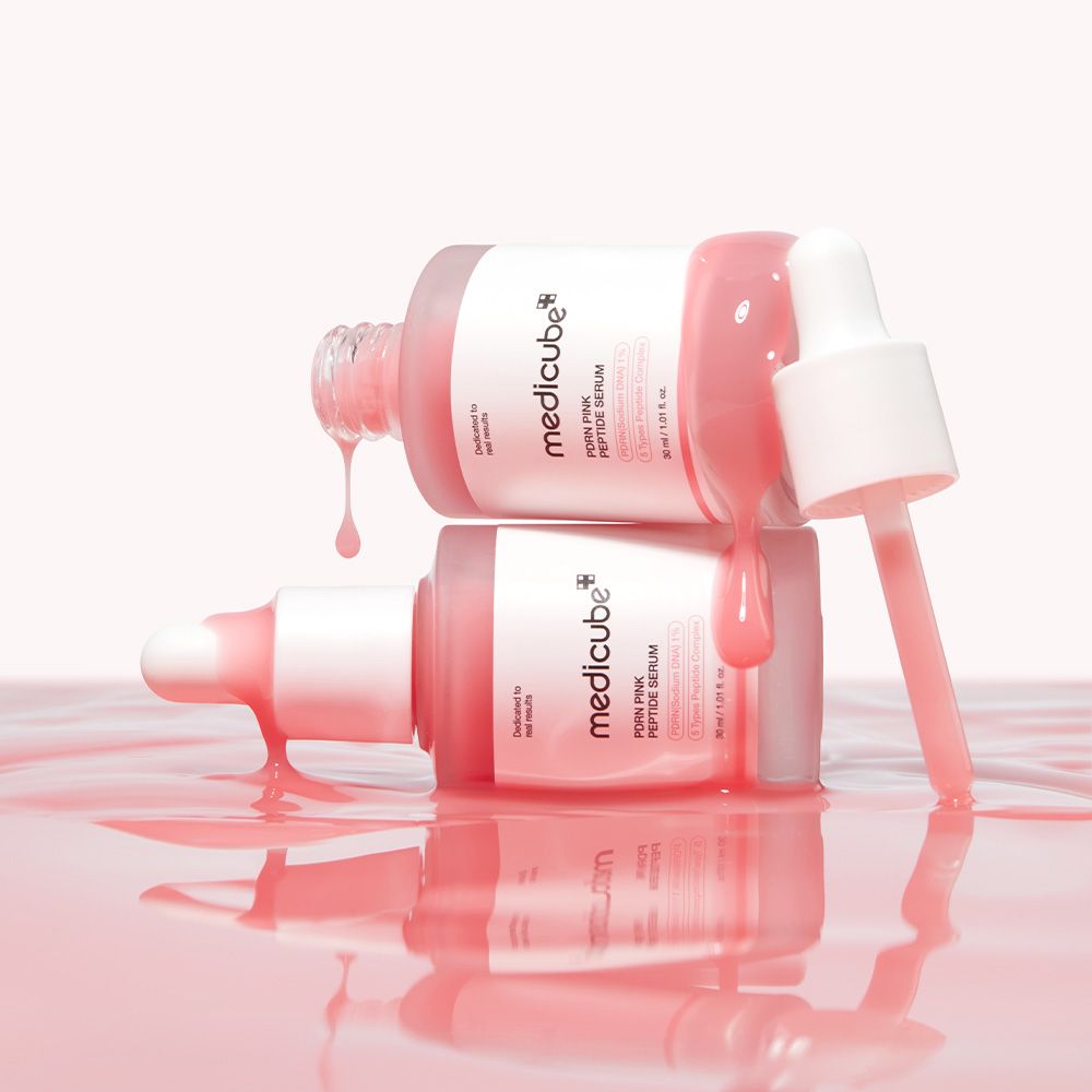 Zwei Medicube PDRN Pink Peptide Serum Flaschen, eine überlappend, mit rosa Flüssigkeit.