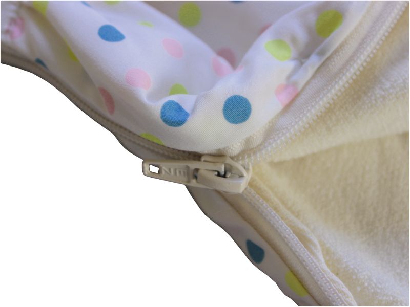 Nahaufnahme des Reißverschlusses eines Schlafsacks. Beige Reißverschluss. Stoff mit bunten Punkten.