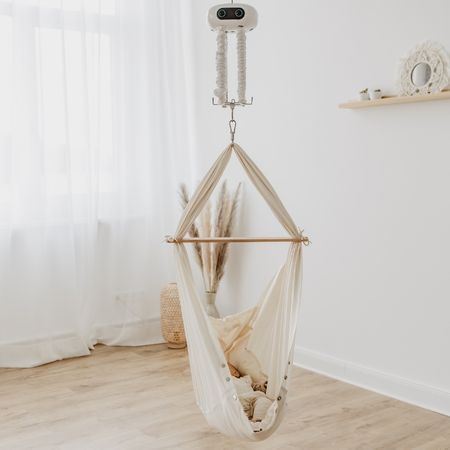 Babyhängematte, an der Decke befestigt. Aufhängung mit Motor. Beige Stoff, Holzstab.