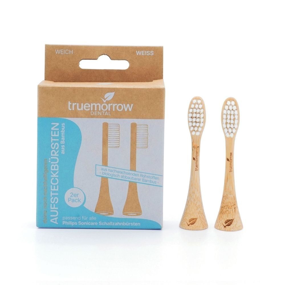 Zwei Bambus-Aufsteckbürsten neben Verpackung. Verpackung mit Aufschrift "truemorrow" und "Aufsteckbürsten".