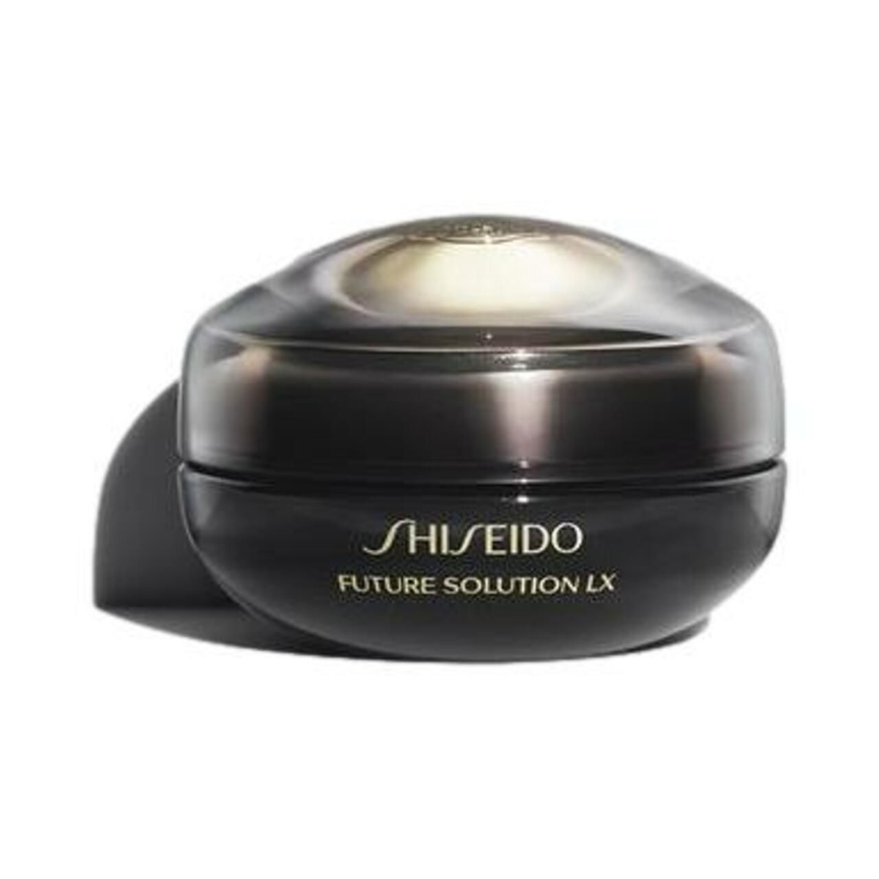 Schwarzer Tiegel mit transparentem Deckel. Aufschrift: SHISEIDO FUTURE SOLUTION LX. Goldfarbener Deckel. Schattenwurf.