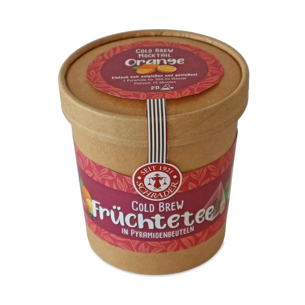 Zylindrische Pappdose mit Deckel. Aufschrift: Schrader Cold Brew Früchtetee. Etikett mit Orange. Siegel.