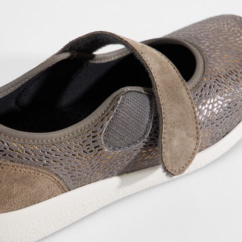 Grauer Damenschuh mit Klettverschluss und floralem Muster.