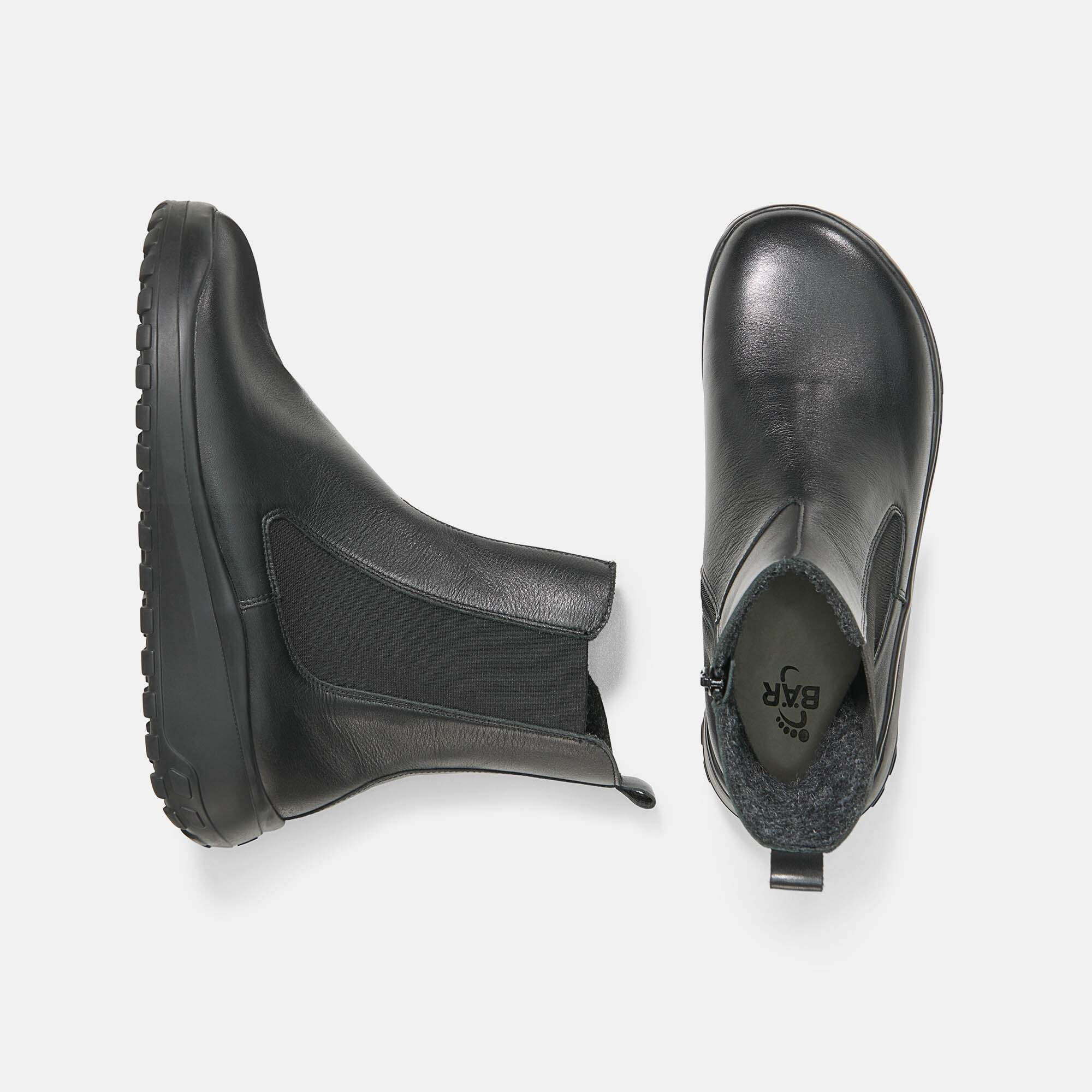 Zwei schwarze Stiefeletten mit breiter Passform. Reißverschluss, elastischer Einsatz und Profilsohle. Innenfutter aus grauem Stoff.