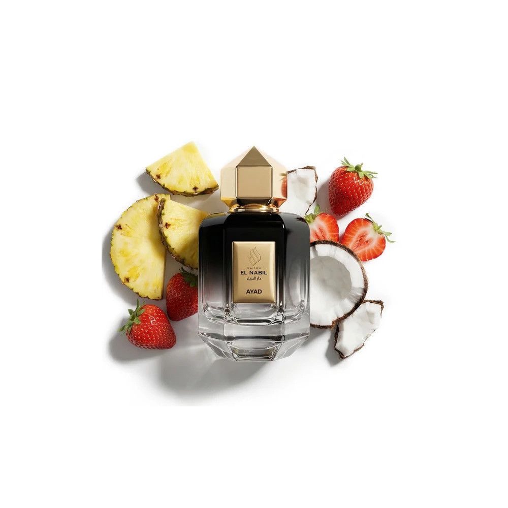 Schwarze Glasparfümflasche mit goldenem Verschluss, umgeben von Ananas-, Erdbeer- und Kokosnussscheiben.