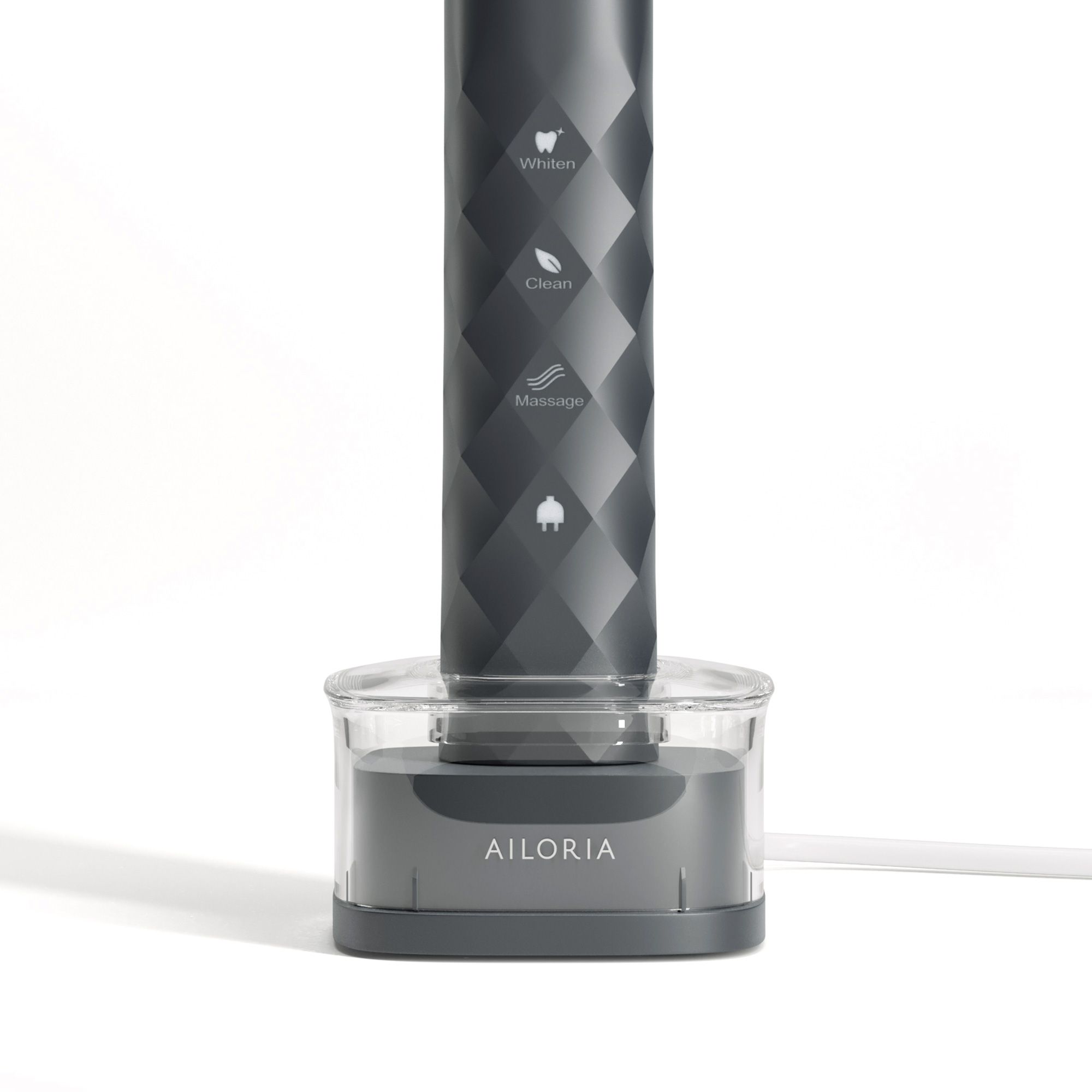 Induktive Ladestation mit Zahnbürste. Graues Gehäuse mit transparentem Behälter. AILORIA-Schriftzug.