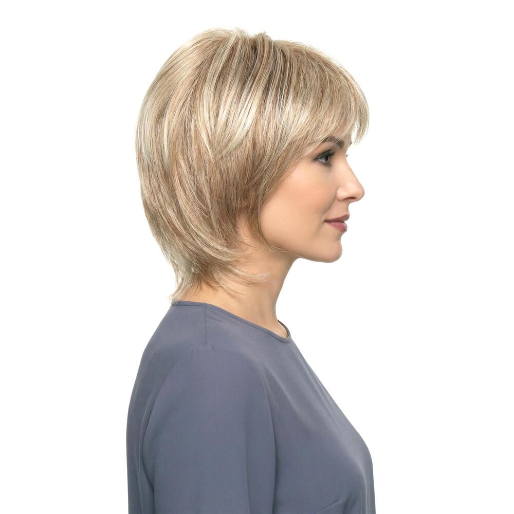 Blond gefärbte Perücke mit kurzem, gestuftem Schnitt. Seitenansicht einer Frau mit grauem Oberteil.