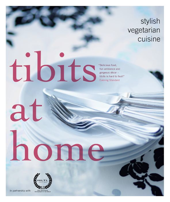 Buchcover: "tibits at home English Edition". Teller mit Besteck. Text: "Stylish vegetarian cuisine". HILTL-Logo.