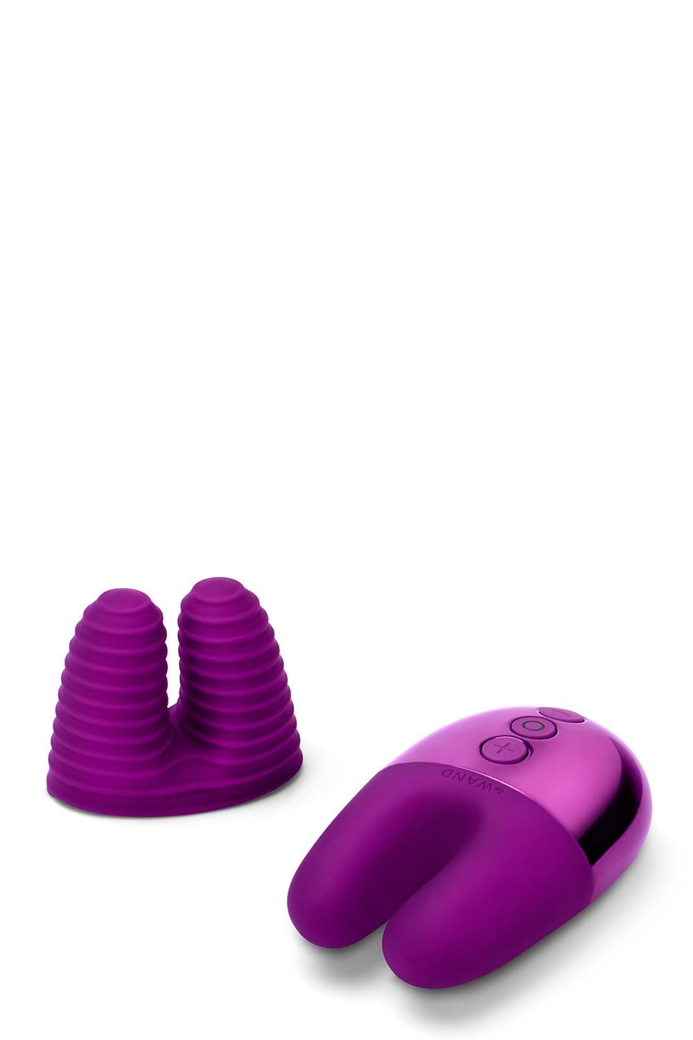 Lila Vibrator mit U-Form und geriffelter Spitze. Neben dem Vibrator liegt ein abnehmbarer Aufsatz mit geriffelter Oberfläche.