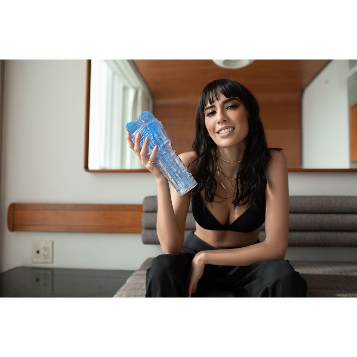 Eine Frau hält ein transparentes, blaues Wellness-Produkt. Das Produkt hat eine zylindrische Form mit strukturierten Oberflächen.